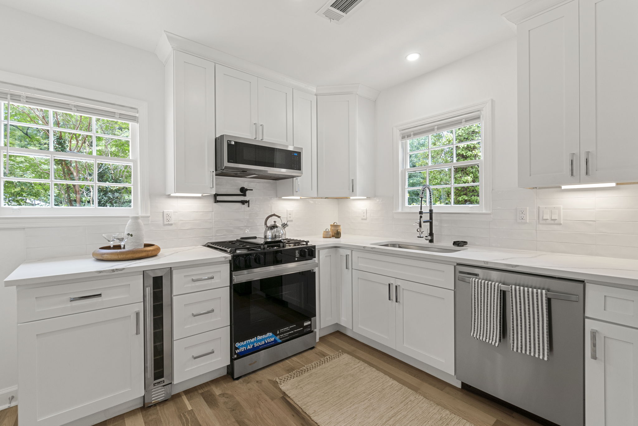 Kitchen - Culinary dreams come true in this gourmet kitchen featuring sleek stainless-steel appliances, quartz countertops, and high-end additions such as a built-in wine cooler, pot filler and glass rinser, to name a few.