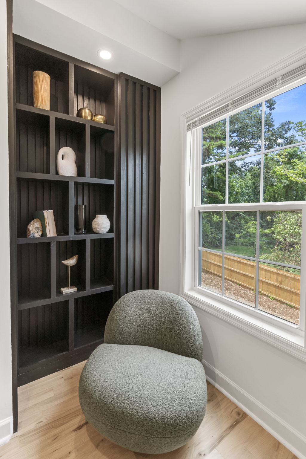 Built-In Library - Upon ascending the private staircase to the primary suite, discover a custom built-in library adjacent to a large window, complete with a tranquil sitting area.