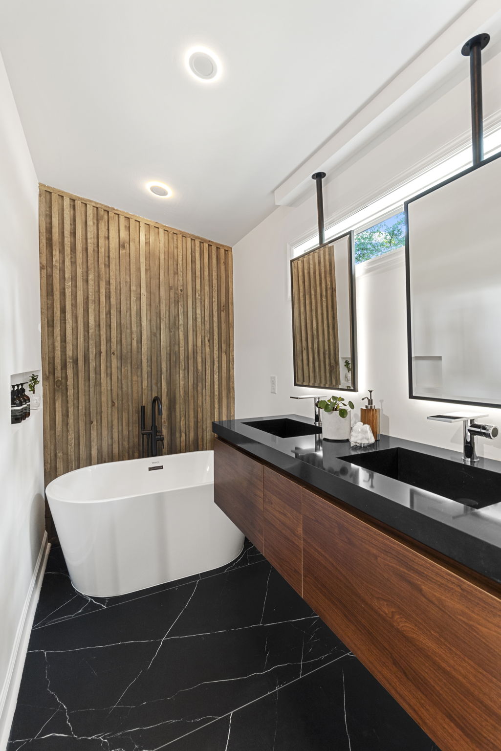 Primary Suite Bathroom - Experience ultimate relaxation in this spa-inspired bathroom, complete with a freestanding soaking tub, walk-in shower, and dual walnut floating vanity.