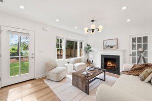 Living Room - Experience warmth and elegance in the living room, where a cozy fireplace and Nordic-style whitewash hardwood floors create a welcoming atmosphere.