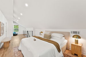 Primary Bedroom - Across the room, a private staircase featuring dimmable LED stair lights ascends to the owner's suite, offering an exclusive retreat within your own home.