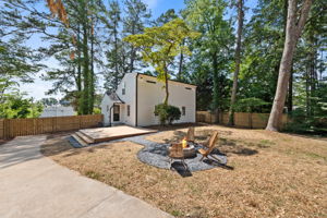 Backyard - Discover limitless potential in this backyard oasis, where the kitchen door opens to an expansive deck that transforms into an entertainer’s haven. Enclosed by privacy fences, this serene retreat offers a spacious deck, inviting fire pit, and lush greenery, creating an ideal setting for gatherings and relaxation with endless possibilities for customization and enjoyment.