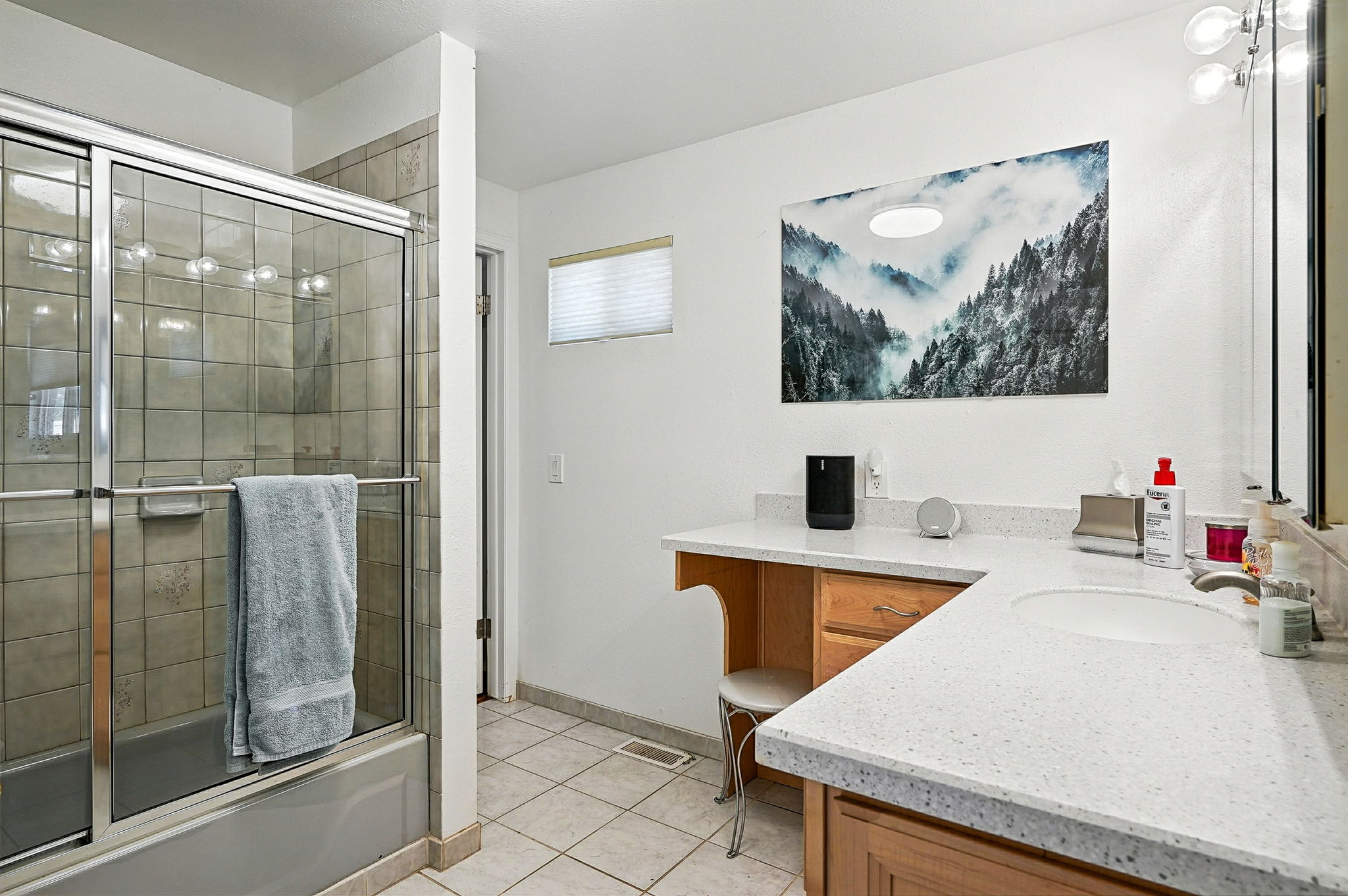 Large bathroom with tub/shower combo is accessible from both the primary bedroom and family room