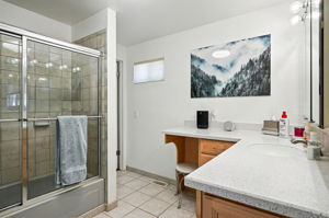 Large bathroom with tub/shower combo is accessible from both the primary bedroom and family room