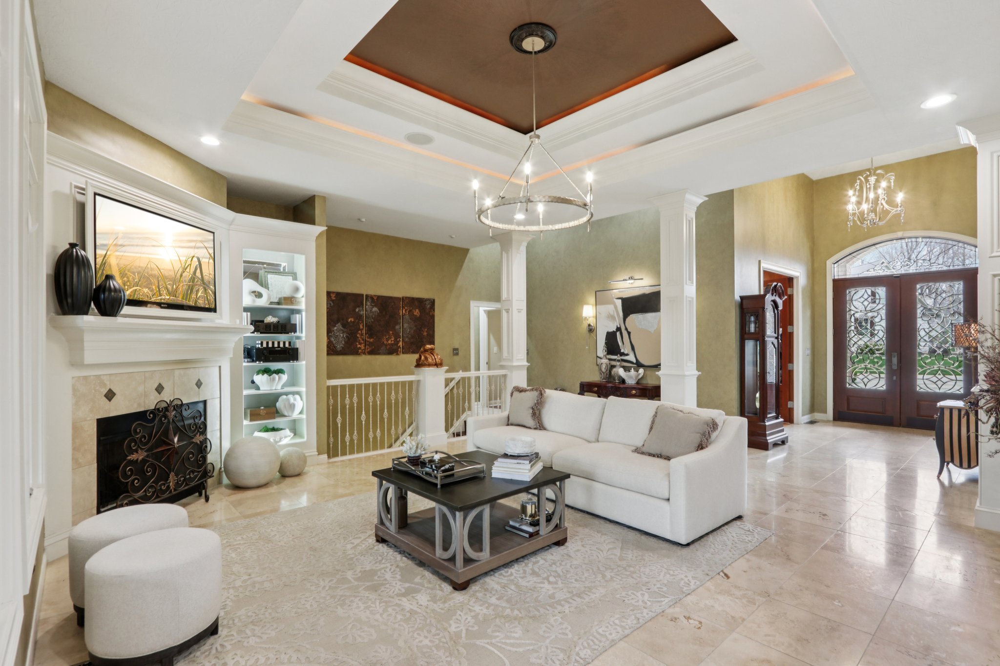 Great room offers ornamental molding, tall ceilings, travertine flooring and surround sound system perfect for entertainment and gathering