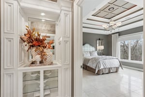 Primary bedroom suite offers ornamental molding, tray ceiling, and great views to the backyard