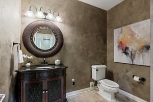 Main level half bath with decorative mirror and wall treatment