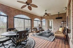 Main level Lanai with arched views of the stunning backyard is extends your living and entertaining area with plenty of room for dining al fresco or enjoying the natural surroundings