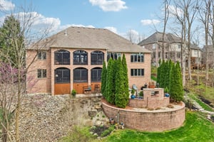 Rear elevation of the home showcasing the Lanais and large paver Tuscan-style paver patio area with gas fireplace