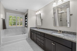 Soaking tub, dual vanities and plantation shutters in primary bath
