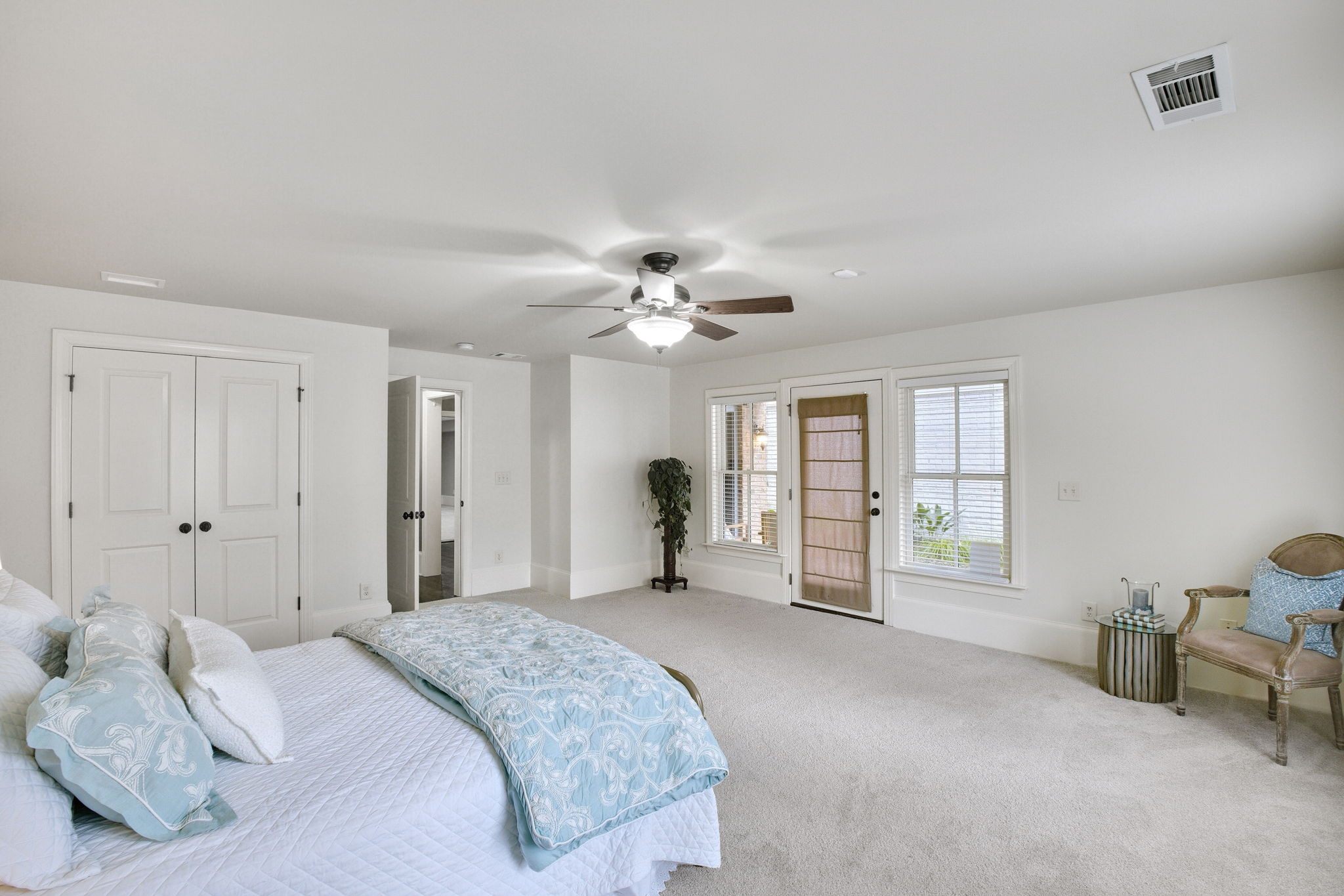 New carpet in this bedroom with a ceiling fan and a large closet