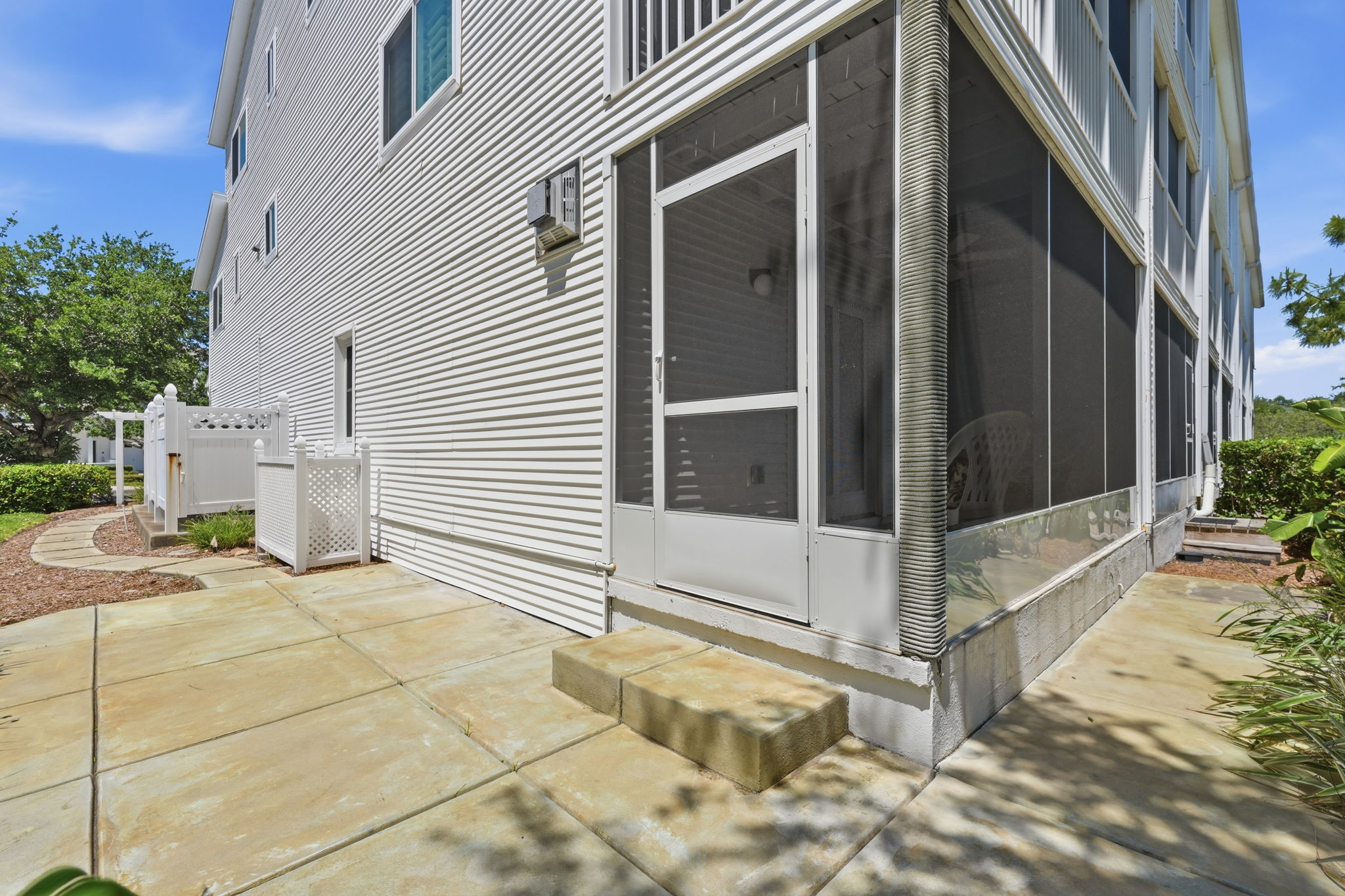 Open concrete patio with concrete walkway to driveway