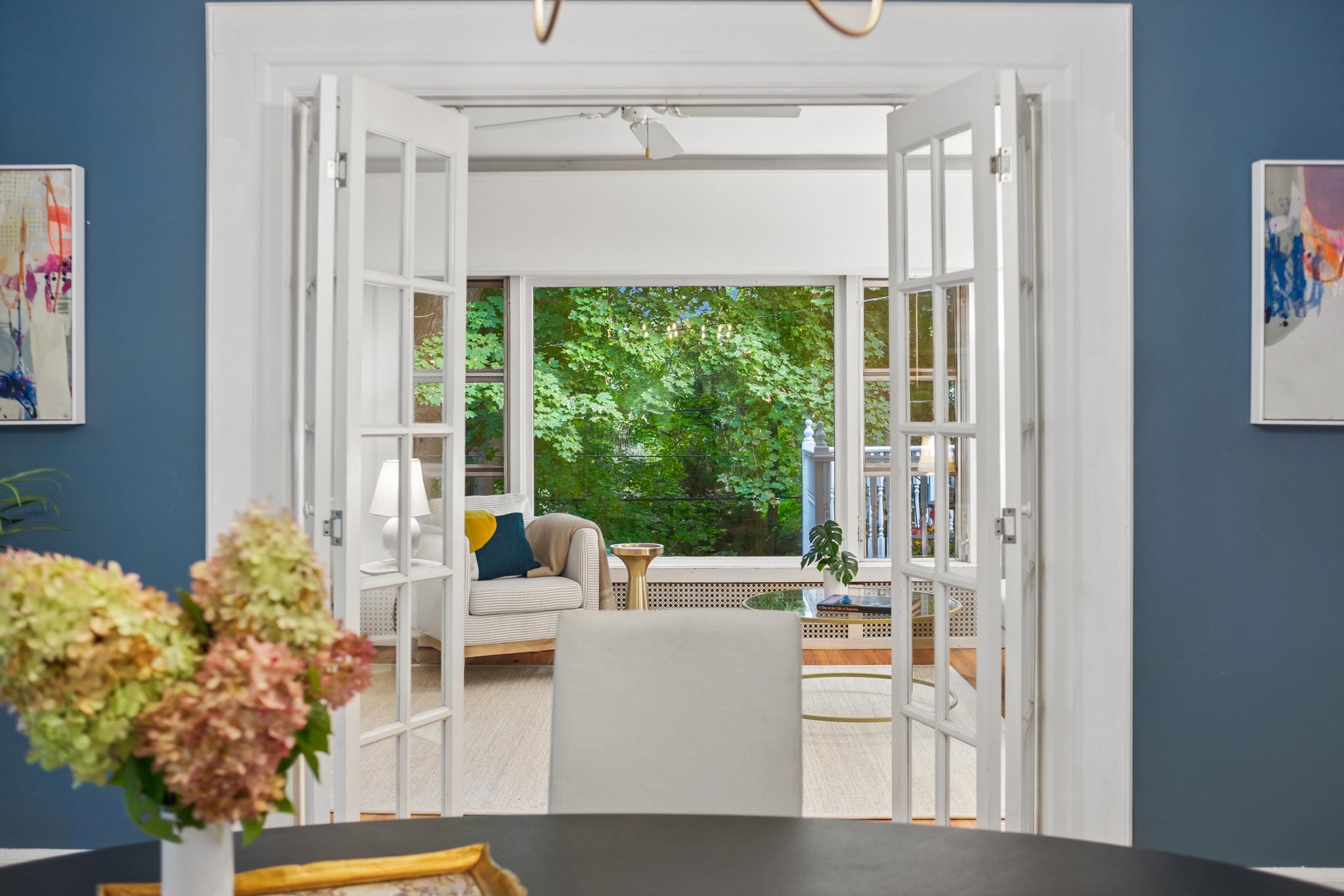A LITTLE REVEAL. French doors frame the family room beyond, drawing your eye through the house to a wall of green.