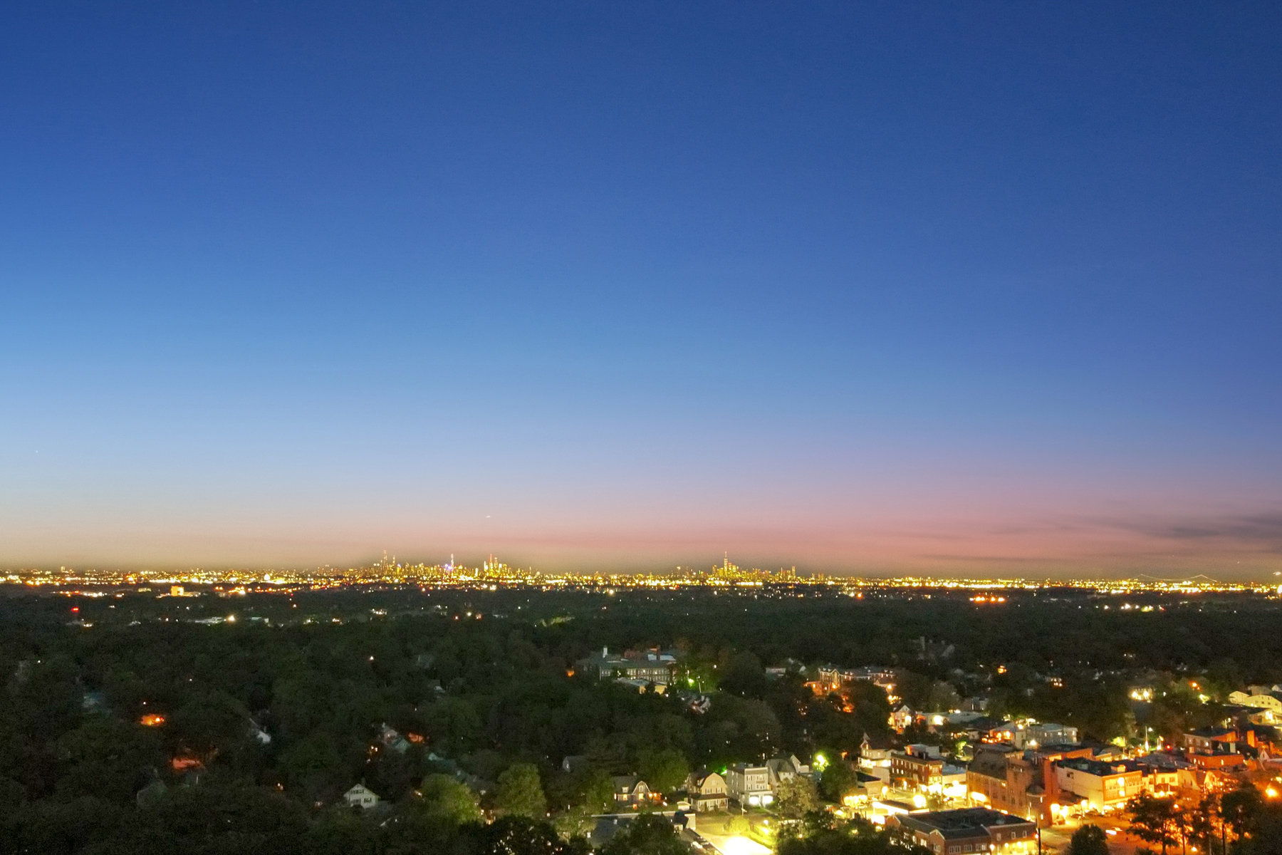 THE BALANCE YOU CAME FOR. Upper Montclair's evening glow, the city's lights beyond and your own quieter corner to return to. Neighborhood aerial; not a view from the property.