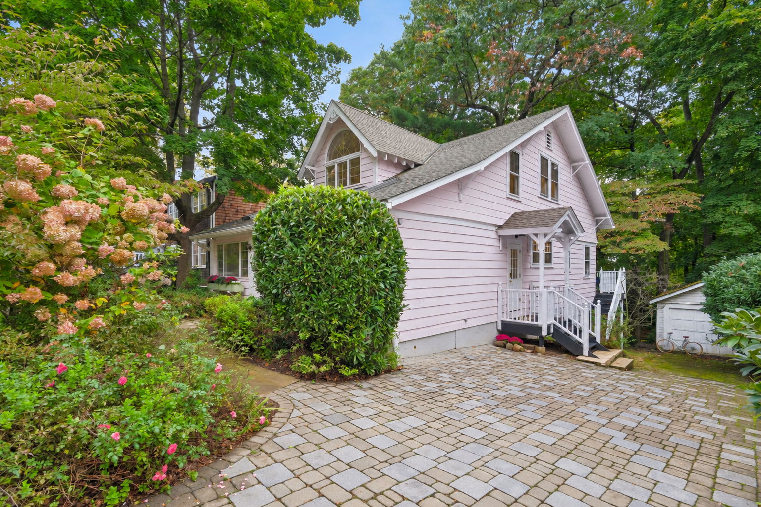 A HOME WITH ITS OWN POINT OF VIEW. A distinctive roofline and Belgian block paving give this Craftsman Bungalow an unmistakable presence. The garden does the welcoming.