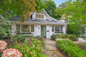 CHARM AT FIRST HELLO. Flower boxes, a garden path and a storybook roofline welcome you to this Craftsman Bungalow. Full of personality, tucked among the trees and ready for your own way of being home.