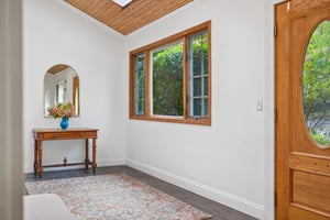 LET YOUR PERSONALITY IN. Warm wood, garden views and room for a collected piece or two make this entrance a lovely place to begin.