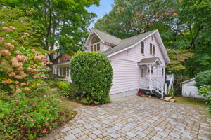 A HOME WITH ITS OWN POINT OF VIEW. A distinctive roofline and Belgian block paving give this Craftsman Bungalow an unmistakable presence. The garden does the welcoming.