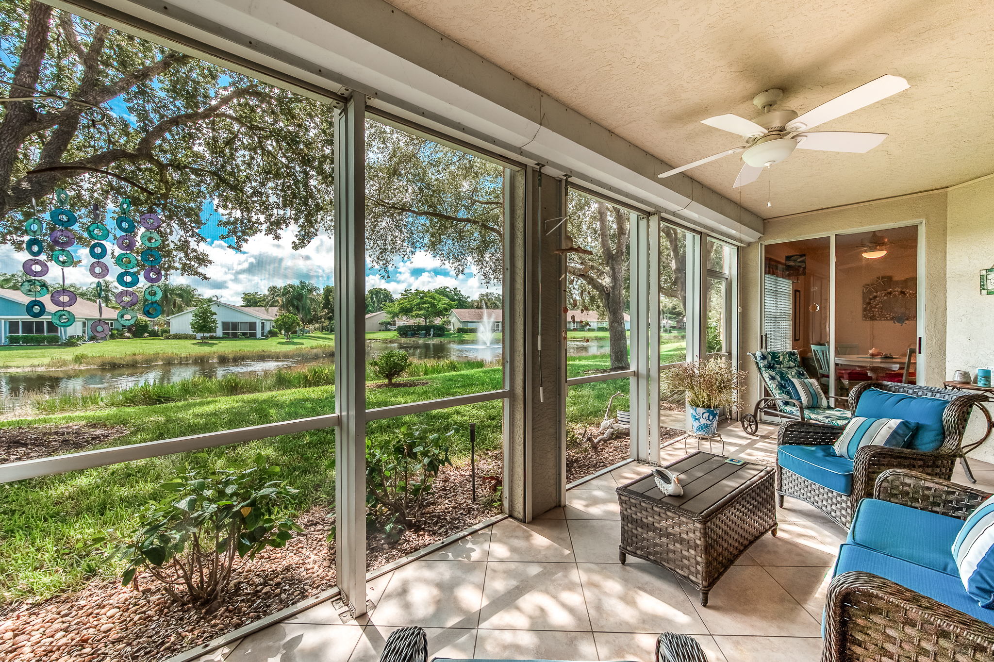 Screened lanai with electric storm shutters facing lake with soothing sounding water feature.