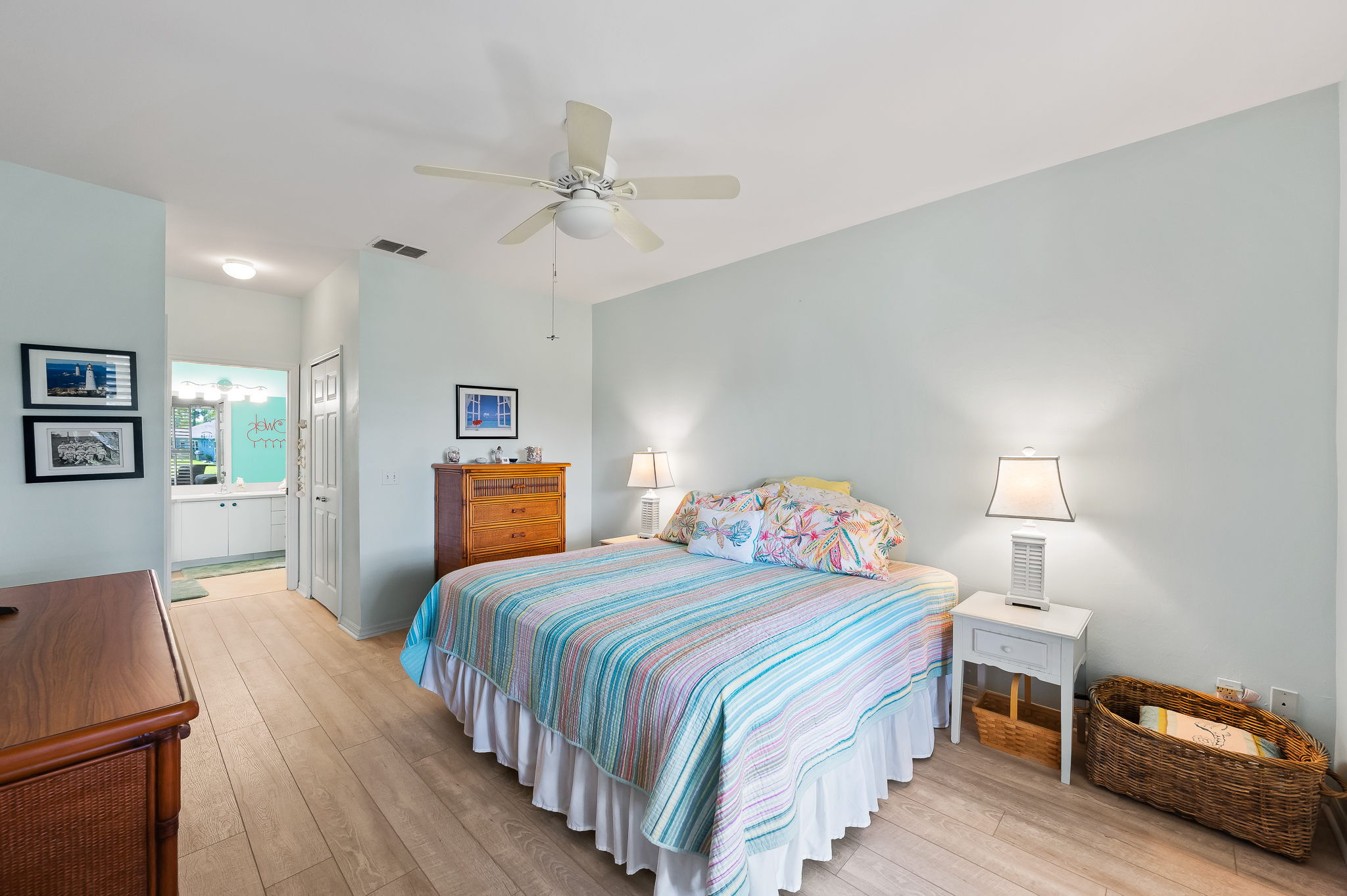 Primary Bedroom with huge walk-in closet and access to lanai. Beautiful water view beyond the sliding plantation shutter panels.