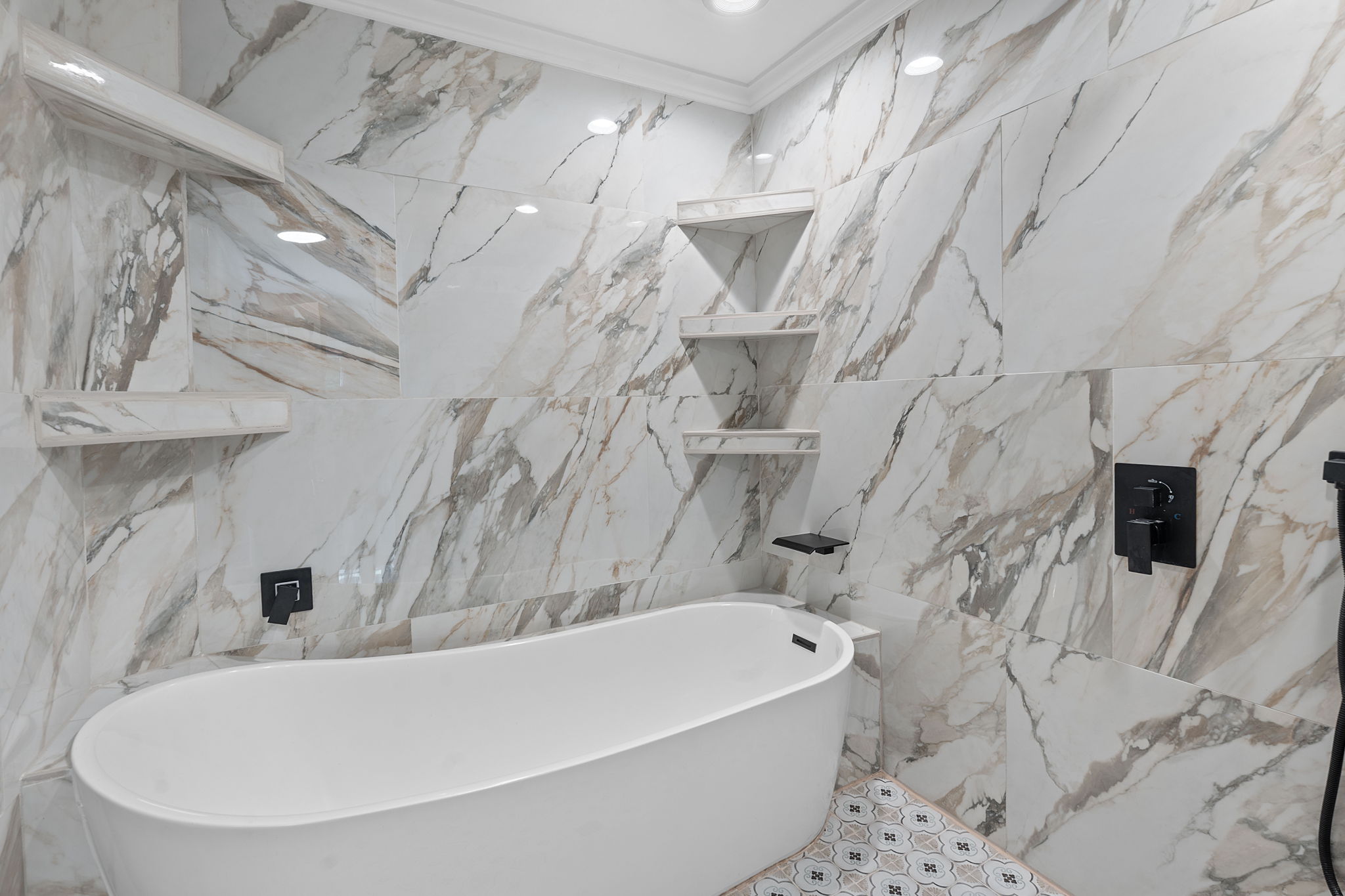 Primary bath's deep soaking tub and dual showers