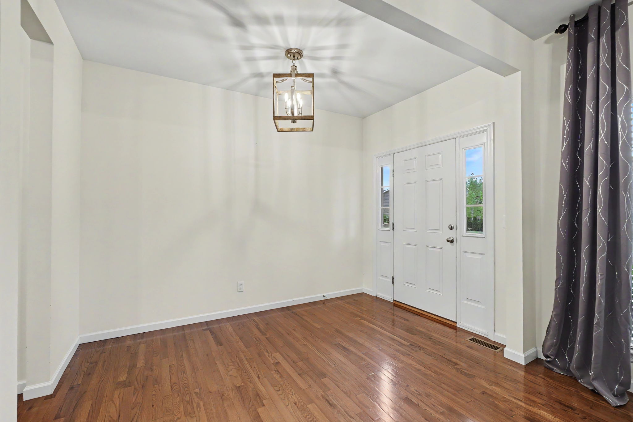 Formal entry foyer showcases 10 ft ceilings and hardwood floors throughout!