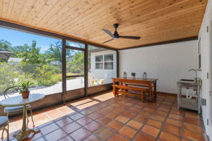 Screened-in back porch with Mexican tile flooring & tongue & groove ceiling with recessed lighting