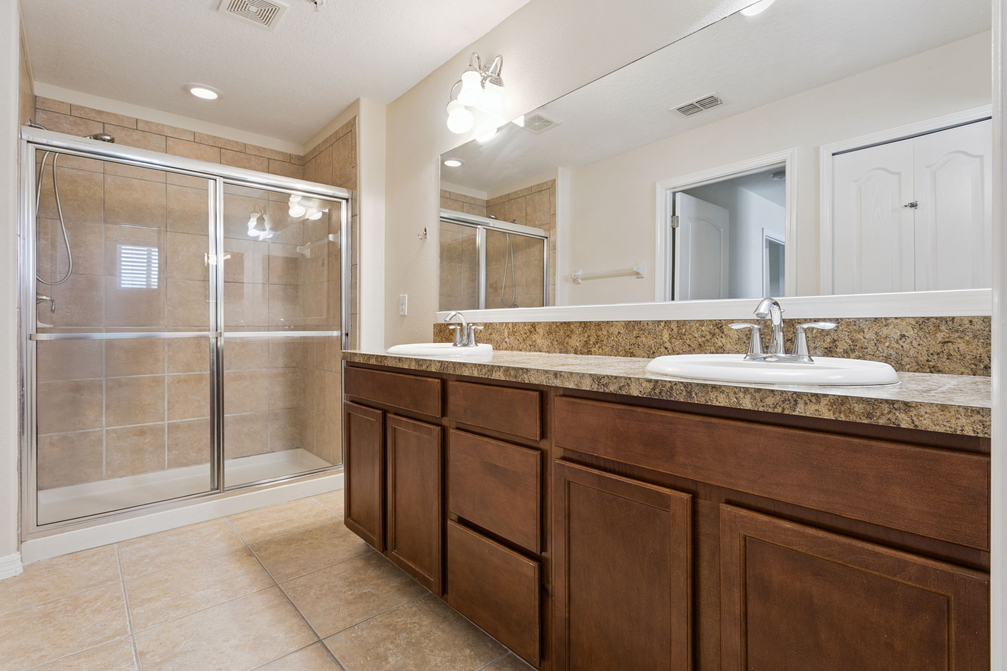 large shower, dual sinks, linen closet and seperate toilet stall