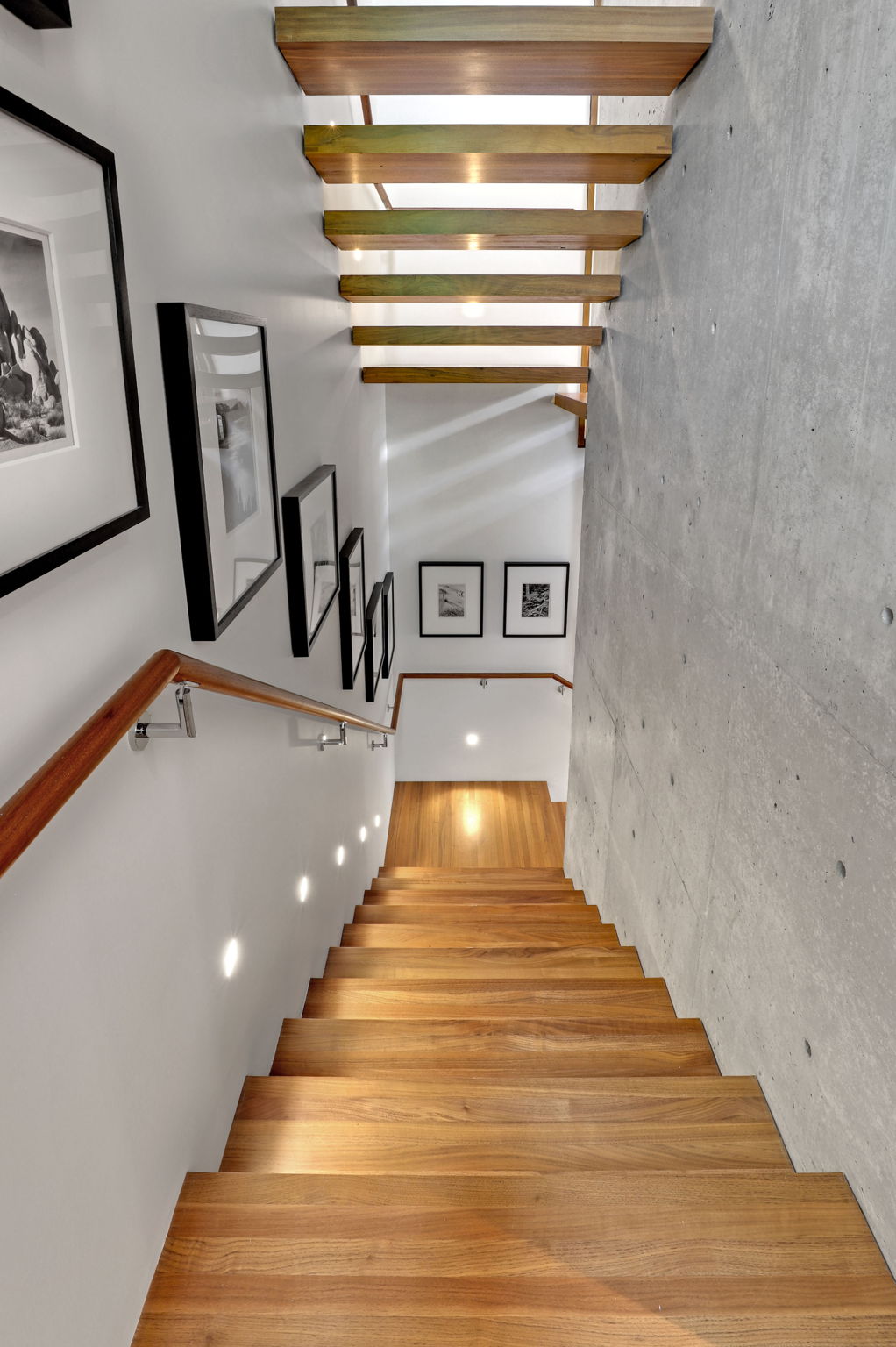 Beautiful walnut staircase has a window at every level.