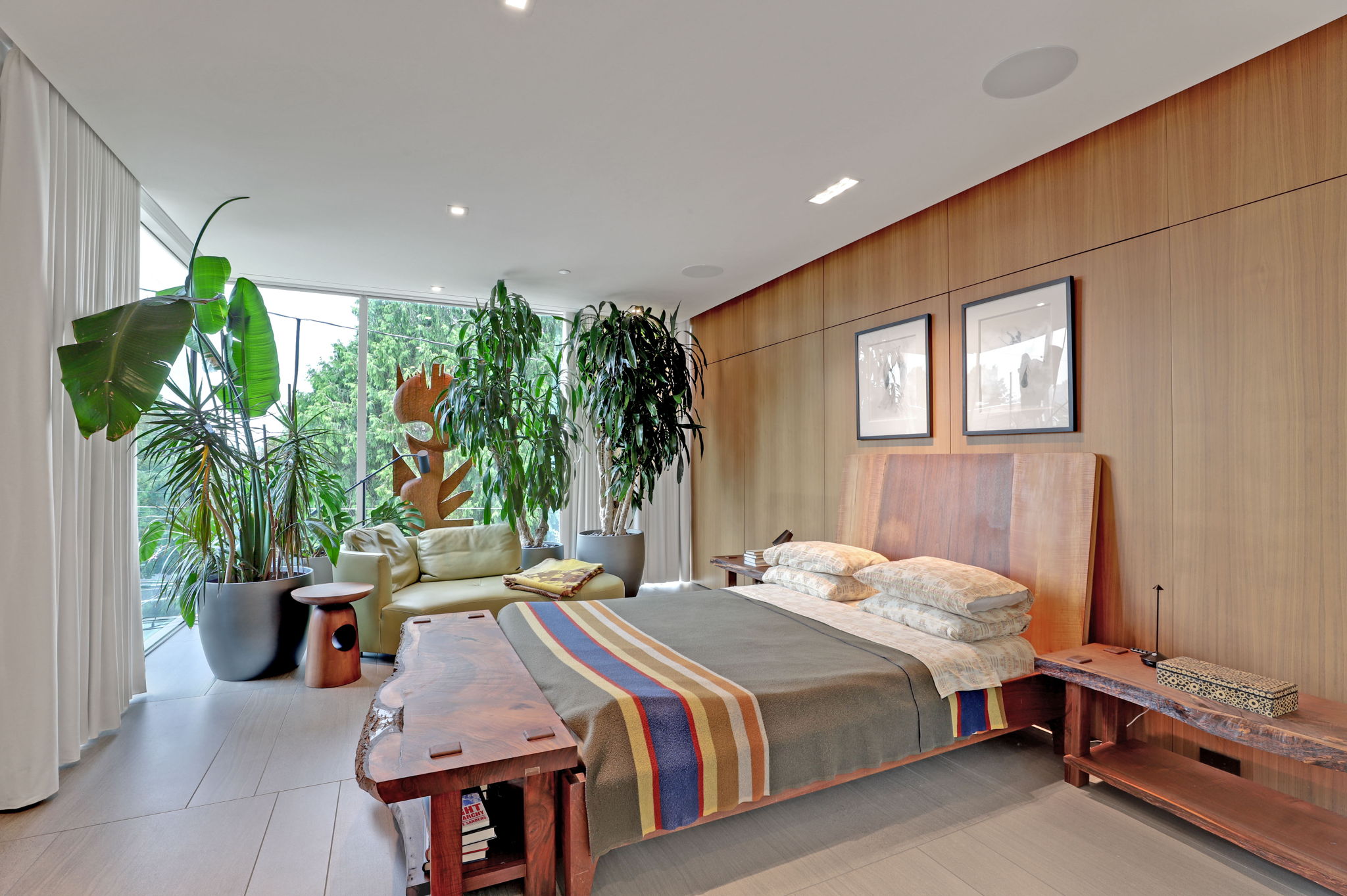 Floor to ceiling windows with automatic shades and curtains. Storage behind wall paneling.