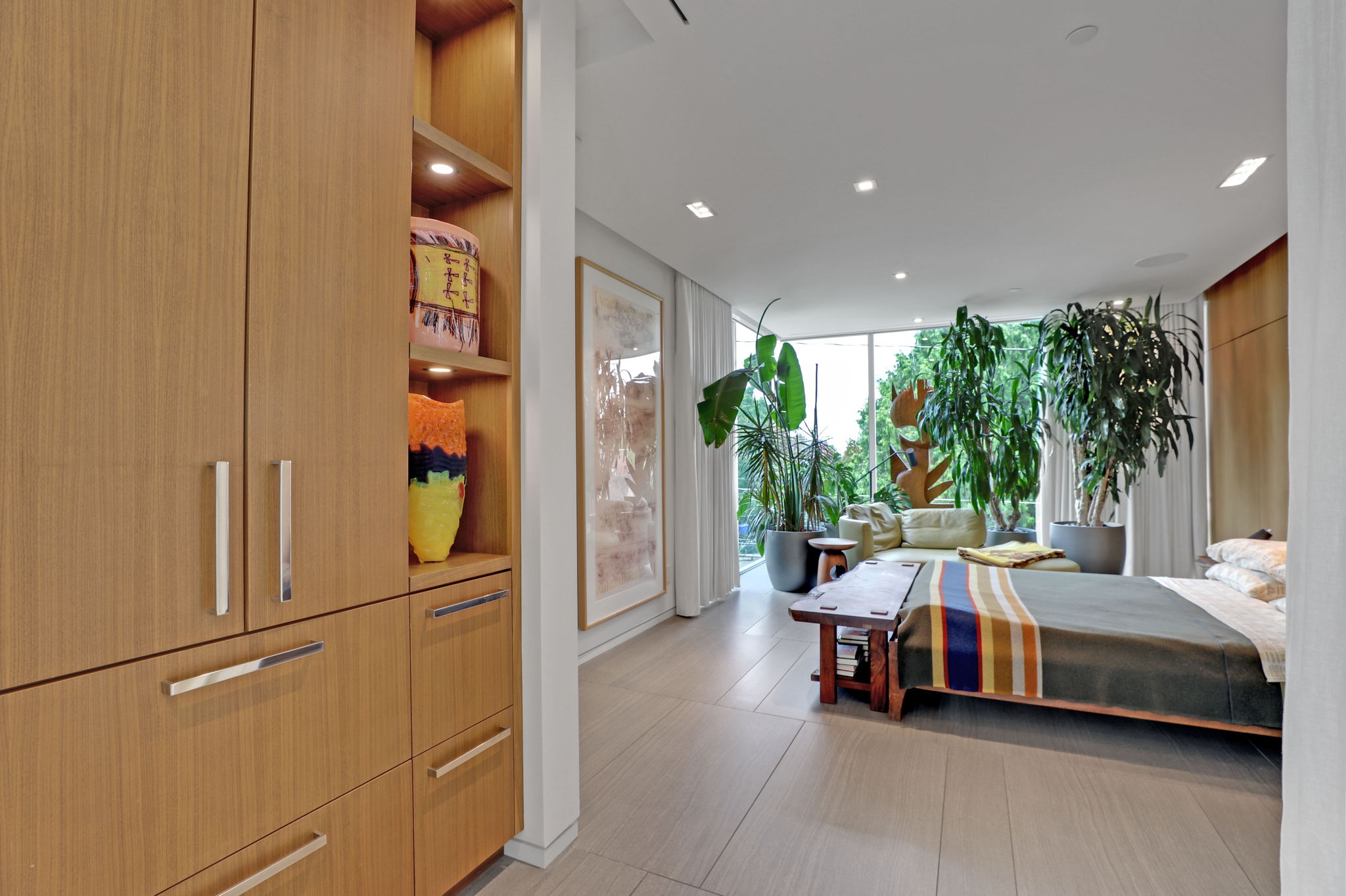 Primary bedroom with gorgeous walnut walls and built-in storage.
