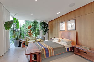 Floor to ceiling windows with automatic shades and curtains. Storage behind wall paneling.