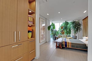 Primary bedroom with gorgeous walnut walls and built-in storage.