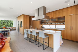 Beautiful white kitchen island balanced by walnut walls and cabinets.
