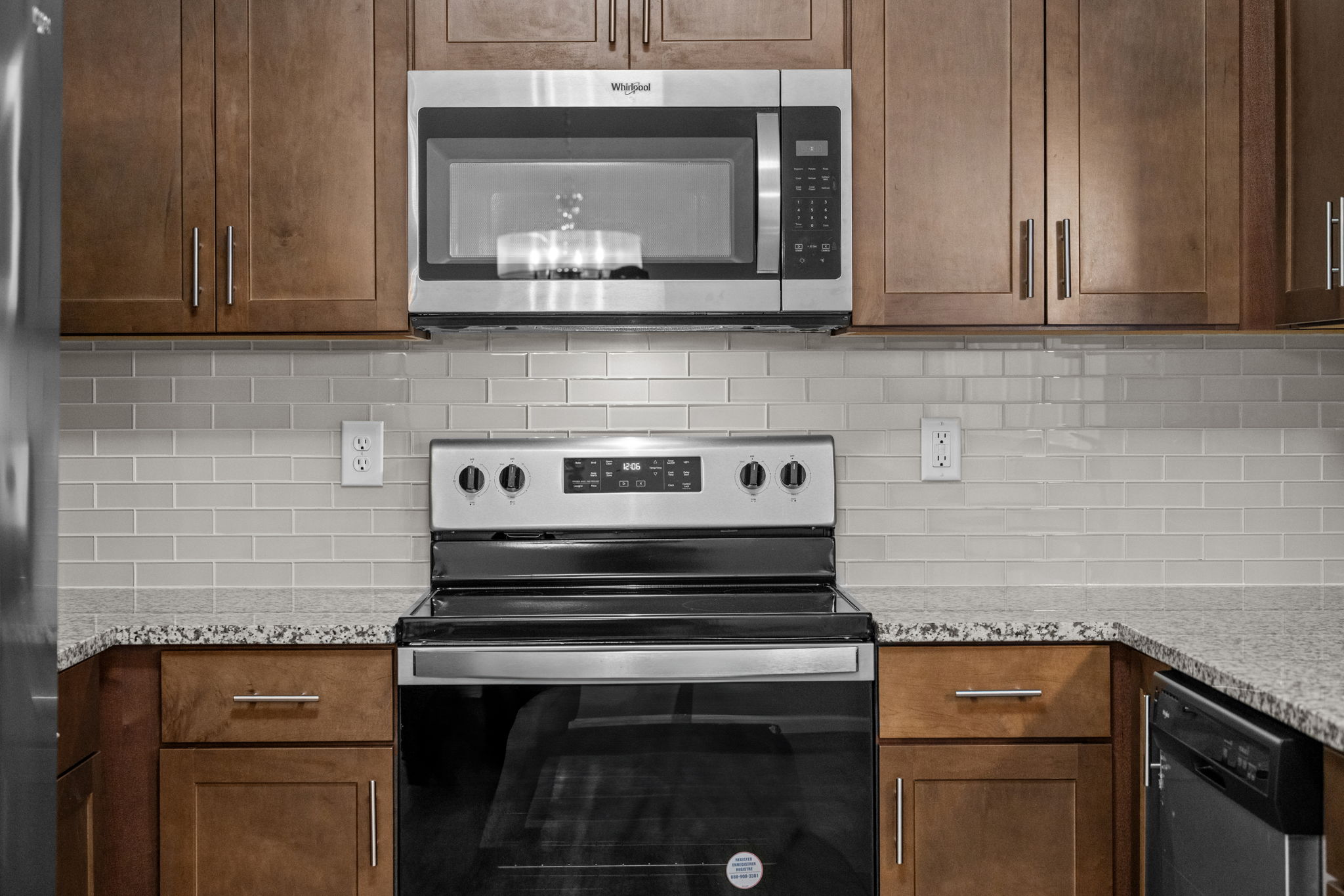 Close up detail of backsplash, cabinets, range/oven & microwave