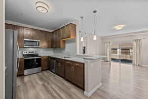 Kitchen towards breakfast bar and family room; Stainless Steel Appliances