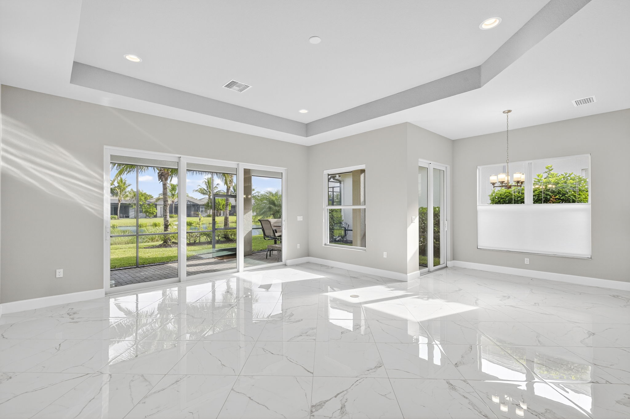 Great room and breakfast area both open to a covered lanai area with lake view.