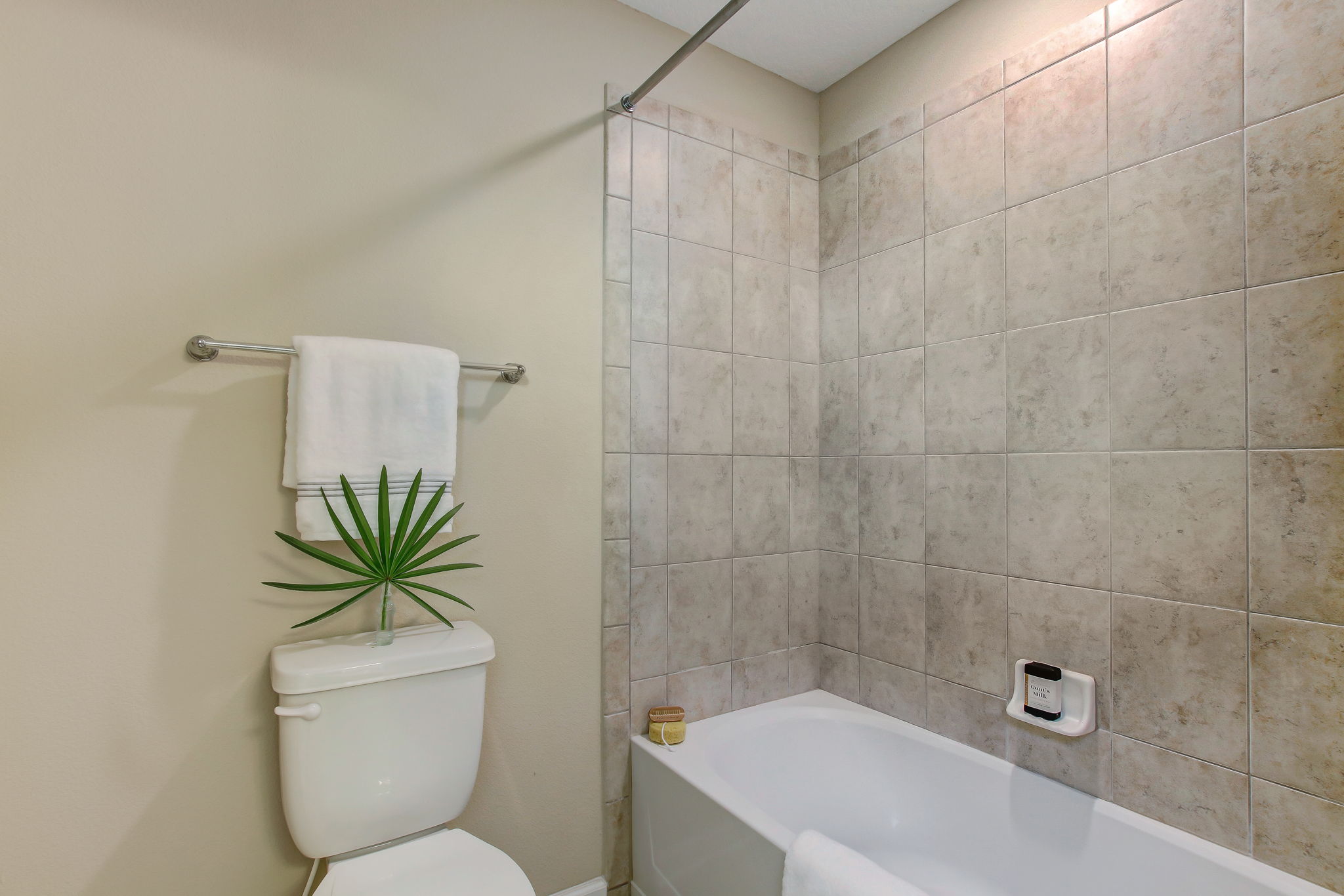 Guest bath features tiled shower and tub
