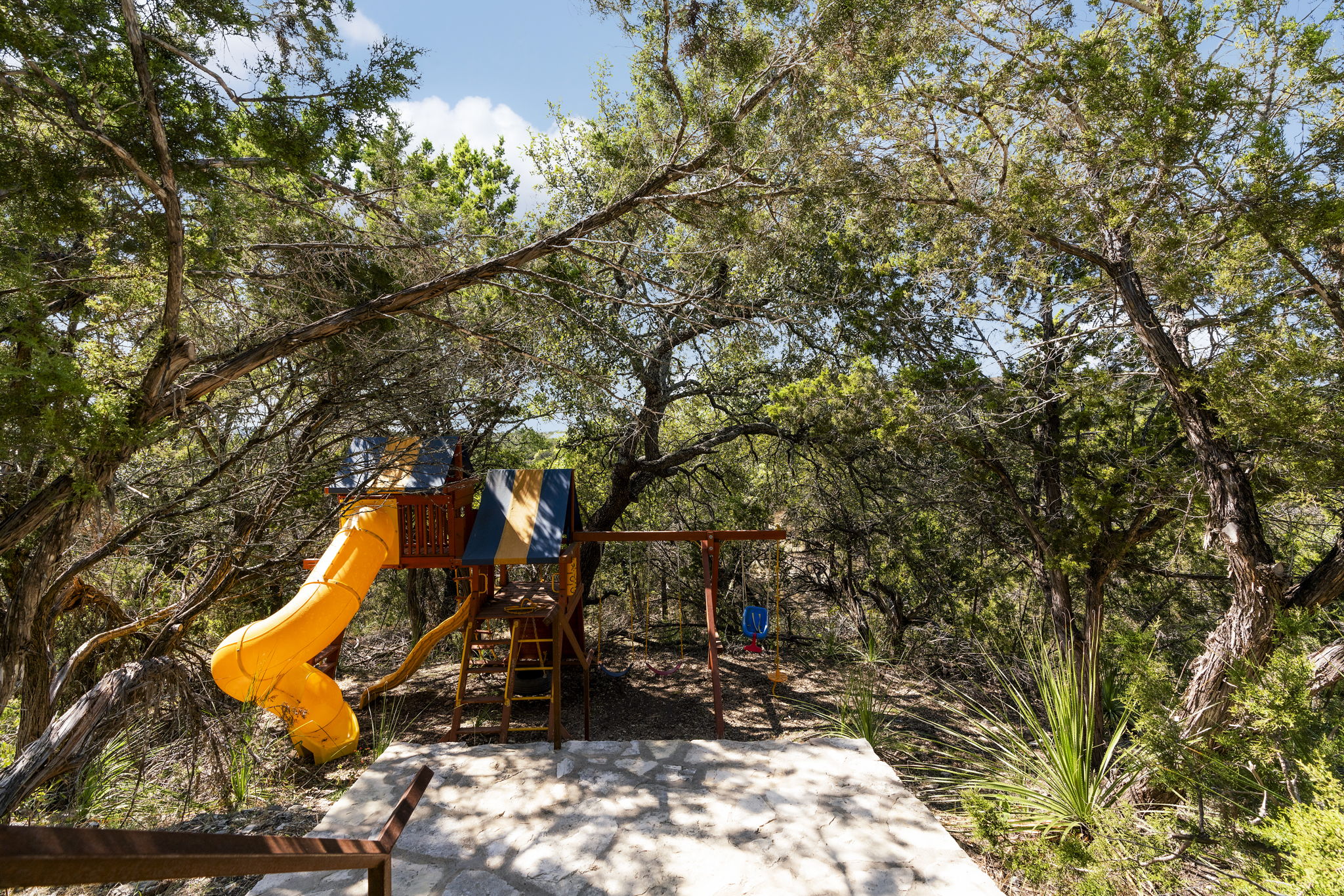 This gated property sits on a 3 acres.The tenants will share the land and this playground with one other unit.