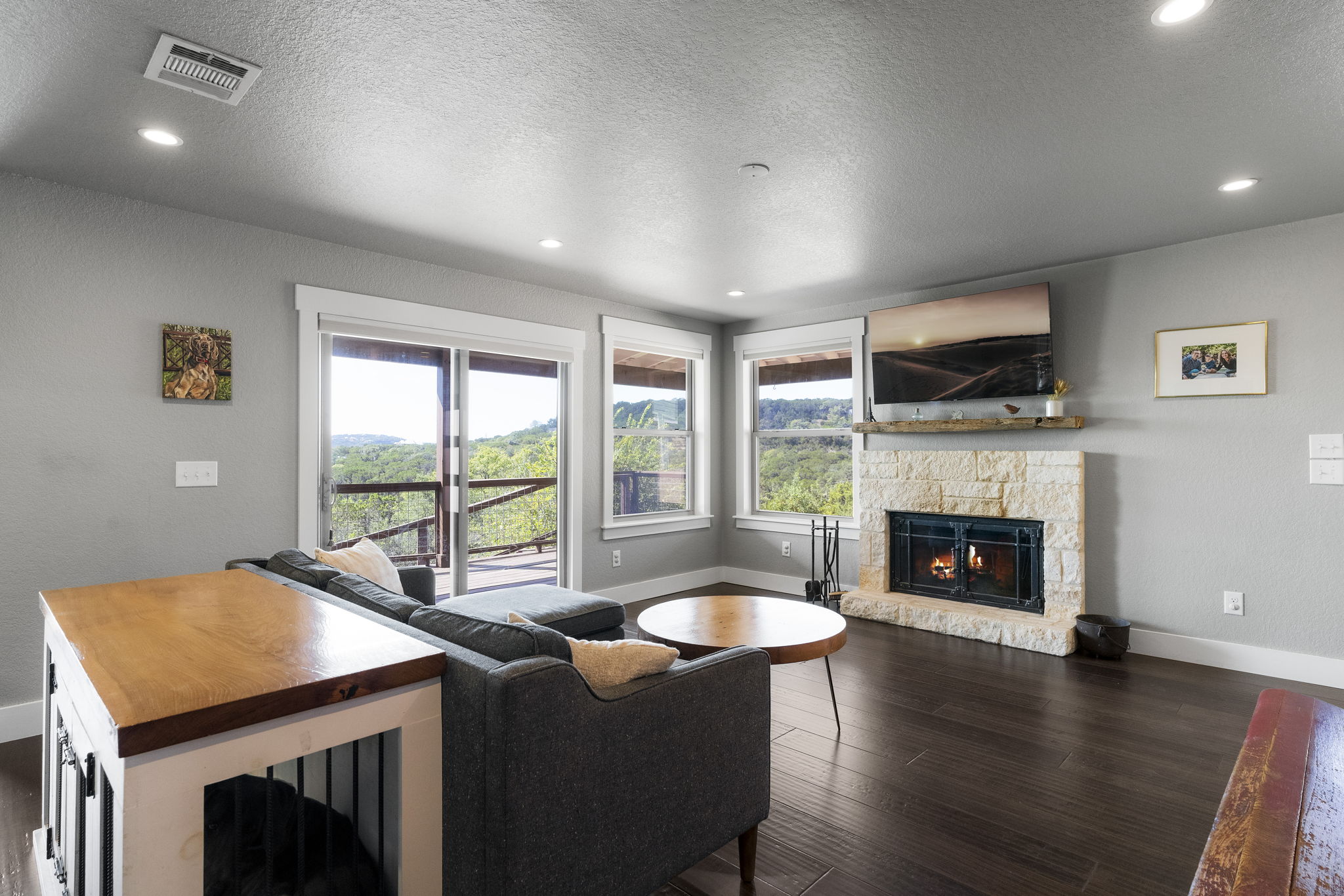 The living room includes a fireplace and showcases beautiful Hill Country views, providing privacy through multiple windows.