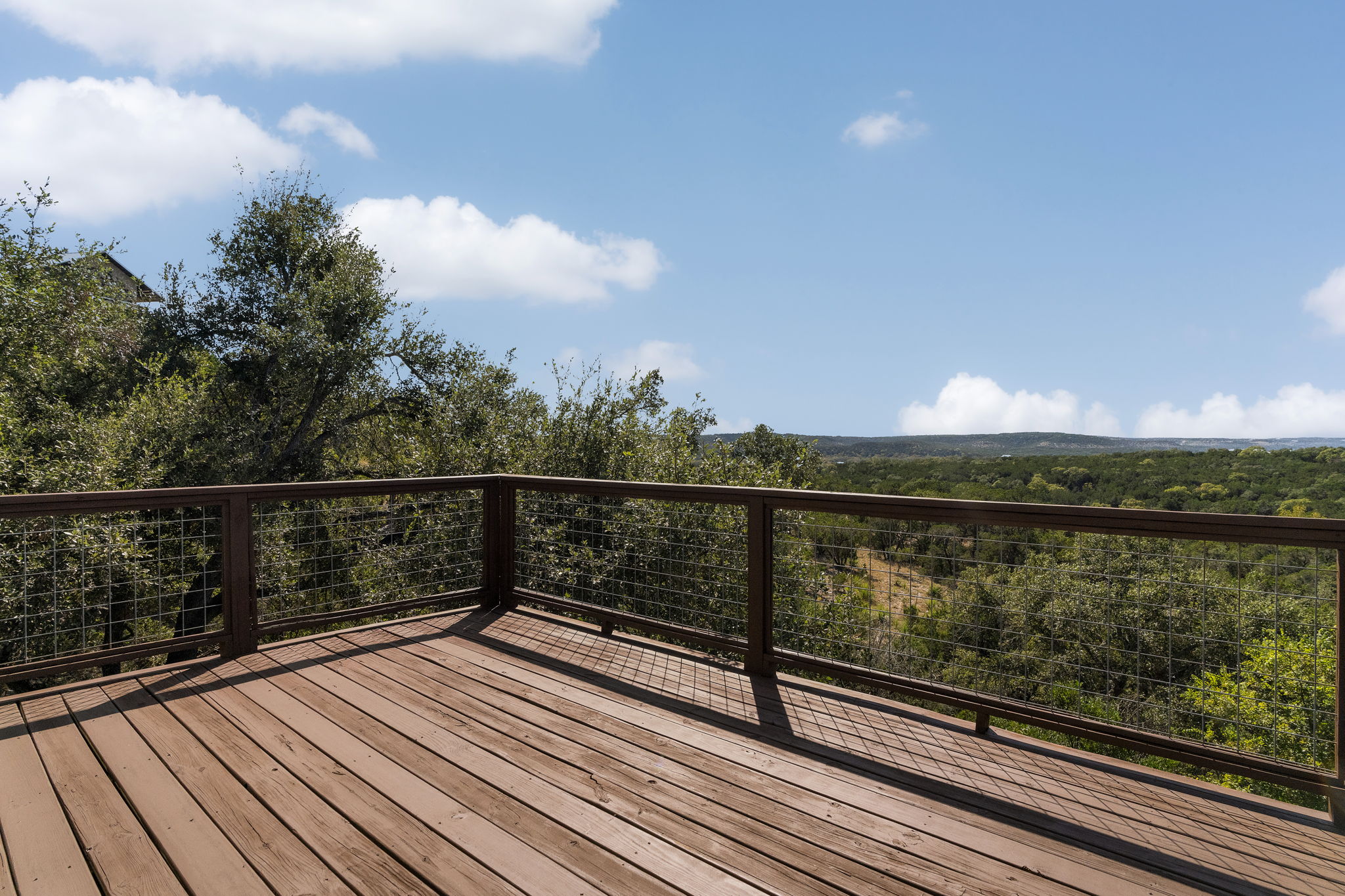 The primary bedroom has its own private deck with Hill Country views