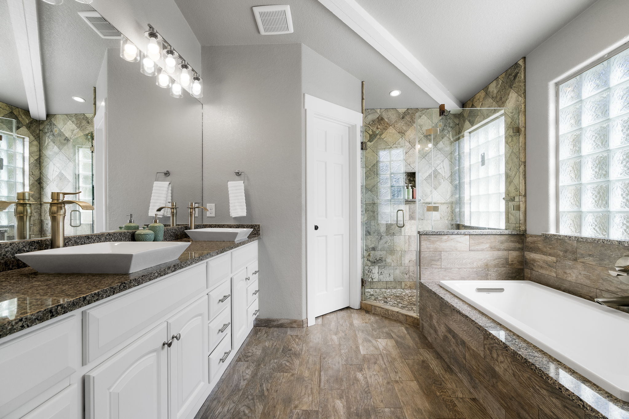 The primary bathroom includes a walk-in shower, a garden tub, a dual vanity, and elegant granite countertops.