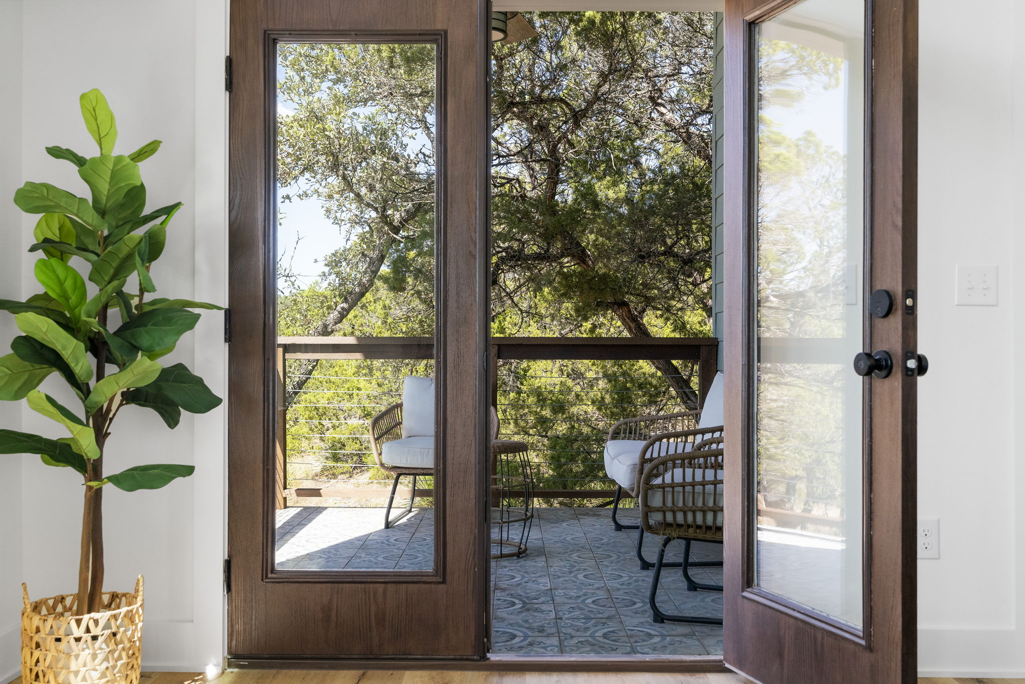 Glass doors open to the modern tiled deck with views that overlook the tranquil beauty of the Wimberley Valley.