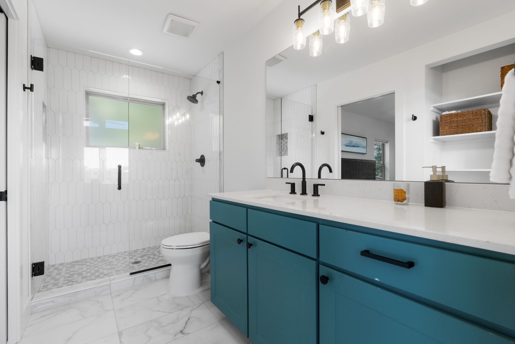 The full bathroom is modern and bright, featuring a spacious walk-in shower.