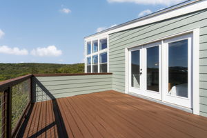 The primary bedroom has its own private deck with Hill Country views