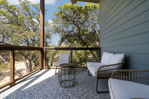 The modern, covered, and tiled deck off of the living room overlooks the tranquil beauty of the Wimberley Valley.