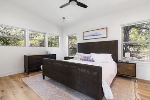 The primary bedroom, with windows overlooking the Hill Country, also features elegant white oak wood floors.