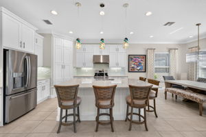 Quartz countertops, designer glass tile backsplash, chimney hood vented to exterior and bar seating for 5 here!