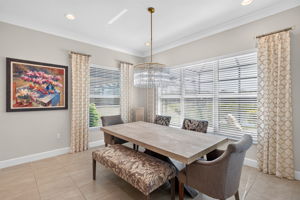 5 windows make this dining area light and bright!Window treatments convey! Statement chandelier present!