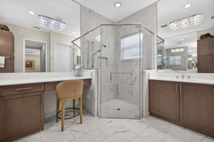 Note seamless shower door, floor to ceiling tile, ceiling height mirrors, and custom lighting.
